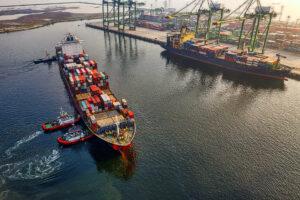 Container feeder is berthing to container terminal with three tugs in assistance